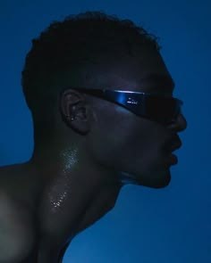 a man with sun glasses on his face in the dark, looking to the side