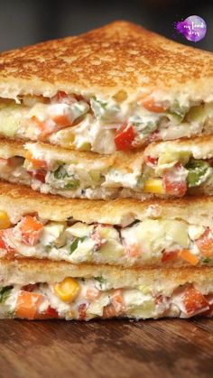 two grilled sandwiches stacked on top of each other with vegetables and cheese in the middle