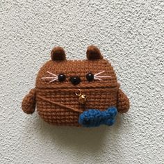 a crocheted cat purse hanging on the wall