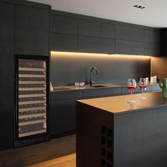 a kitchen with an island and wine glasses on the counter