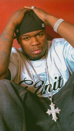 a man sitting on the floor with his hands in his hair and wearing a hat