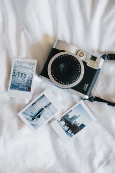 a camera and some pictures laying on a white sheet with the word photos above it