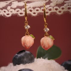 Experience the magic of nature with our Peach Earrings. Featuring a delicate enameled peach adorned with sparkling cubic zirconia, these lovely earrings add a touch of glamour to any style. You'll enjoy the sweetness and cheer of summer they bring to you. Embrace your love for fruit jewelry with these stunning earrings! DETAILS Plating: 18K Gold Materials: 18K Gold on Brass, Enamel, Cubic Zirconia Size: 1.34 "*0.39"(3.4c m*1cm) Weight: 8.3g Cheap Pink Fruit Design Earrings, Delicate Peach Jewelry For Gifts, Orange Enamel Dangle Jewelry, Elegant Apricot Dangle Jewelry, Apricot Drop Earrings For Gifts, Elegant Apricot Earrings For Gift, Peach Drop Earrings For Gift, Cute Orange Drop Earrings, Fruit Necklace