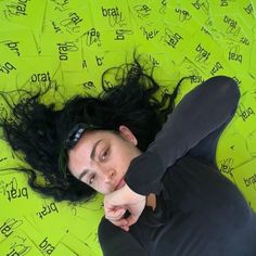 a woman laying on top of a yellow sheet of paper