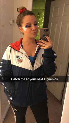 a woman taking a selfie with her cell phone in front of the mirror that says catch me at your next olympics