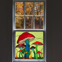 a stained glass window with colorful mushrooms in the center and trees outside it on either side