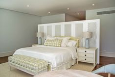 a bedroom with a bed, nightstands and two lamps on either side of the bed