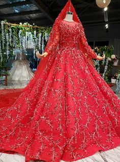 a red wedding gown on display at a bridal event in the middle of a room