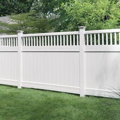 a white vinyl fence in the grass