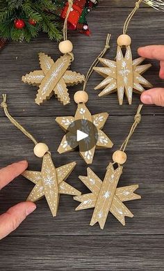 wooden ornaments are being held by two hands