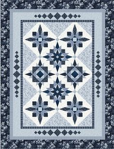 a blue and white quilt with an intricate design on the front, along with a black border