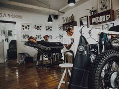 two men sitting in a barbershop with their hair dryers on the floor