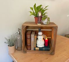 a small wooden shelf with books and candles