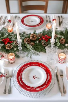 a christmas table setting with pine cones and candles