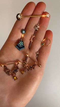 a person's hand holding several different types of jewelry in their palm, with the light shining on them