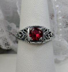 Simulated or Natural (1.3ctw) Red Ruby Ring Valentine Design#211 Custom Made This is a stunning Edwardian style, Victorian wedding reproduction gemstone filigree ring. The simulated or natural round cut ruby red gemstone is 6mm in diameter. This lovely solid sterling silver ring is marked 925 for sterling silver. The ruby is heat and color treated and is i1 - i3. Perfect to show someone how much you care about them, this ring is even etched with the word "love" on each side.  There is beautiful Red Jewelry With Center Stone Round Band, Red Ruby Princess Cut Rings, Red Jewelry With Center Stone In Round Band, Princess Cut Ruby Rings In Red, Red Brilliant Cut Rings For Wedding, Classic Red Jewelry With Lab-created Ruby, Intricate Ruby Wedding Ring, Red Brilliant Cut Wedding Rings, Elegant Princess Cut Ruby Ring For Wedding