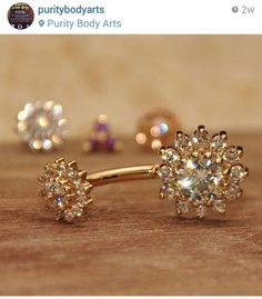 two pairs of gold and diamond earrings on a wooden surface with the words purify body arts written below them