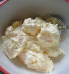 a white bowl filled with food next to a spoon