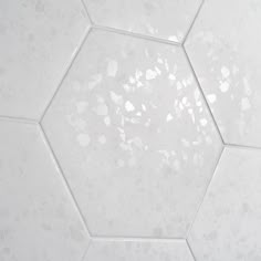 a white hexagonal tile floor with small holes in it