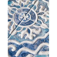 an artistic blue and white tile design with snow flakes in the center, on top of it