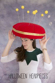 a woman wearing a red hat with yellow pins on it's top and the words halloween headpieces above her head