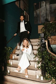 the bride and groom are sitting on the stairs