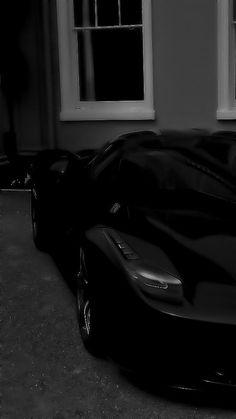 a black sports car parked in front of a window