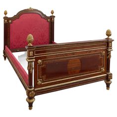 an antique bed with red upholstered headboard and foot board, made in the late 19th century