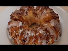 a bundt cake sitting on top of a white plate covered in icing and drizzle