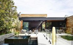 an outdoor dining area with tables and chairs next to a water feature in the pool