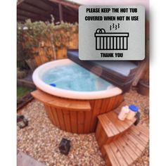 a hot tub sitting on top of a gravel covered ground next to a wooden bench