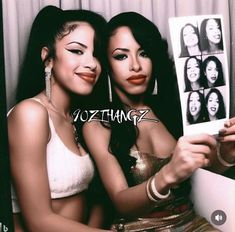 two beautiful young women sitting next to each other holding up pictures and posing for the camera