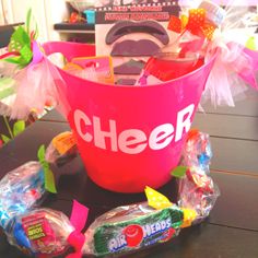 a pink bucket filled with candy sitting on top of a table