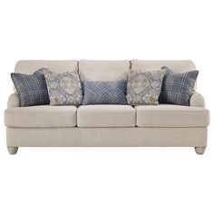 a white couch with blue and gray pillows