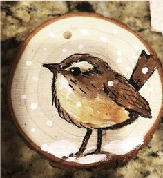 a small bird painted on a piece of wood