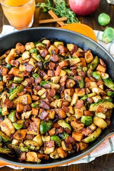 a pan filled with cooked vegetables on top of a wooden table next to an iphone