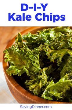 a wooden bowl filled with lettuce sitting on top of a table next to a napkin