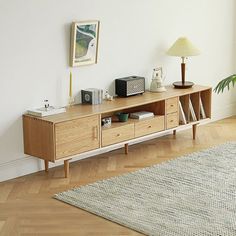 a living room with a large rug and a wooden entertainment center on the floor next to a window