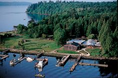 an aerial view of a house on the water with boats docked in front of it