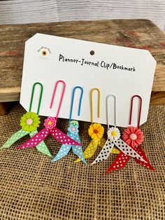 several colorful pinwheels with polka dots and flowers on them sitting next to a sign that says planner - journal clip bookmark