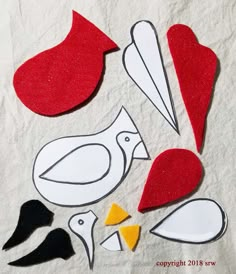 paper cut outs and scissors on top of a piece of white paper with red and black shapes