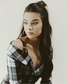 a woman with long hair wearing a plaid shirt