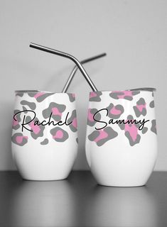 two white cups with pink and gray leopard print, one has a straw in it