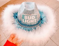 a blue hat with the words bud light written on it and white feathers around it