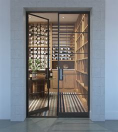 an open door leading into a room filled with wooden shelves