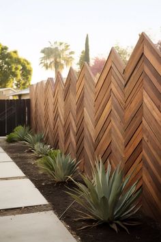 a wooden fence is lined with succulent plants