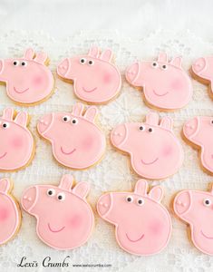 decorated cookies in the shape of peppa pigs on a lace tablecloth with white doily