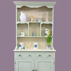 a white china cabinet with blue and yellow flowers