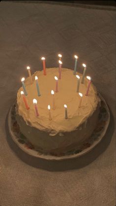 a birthday cake with many lit candles on it