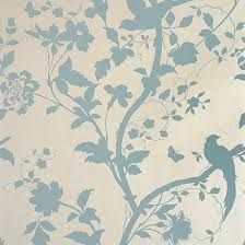 a bird sitting on top of a tree branch next to a flowery wallpaper